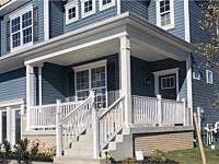 <b>A front yard porch with white vinyl railing</b>